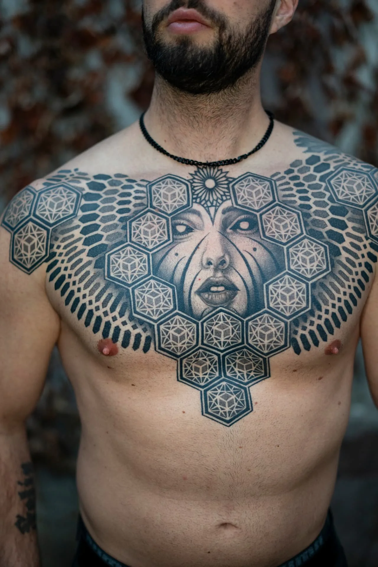 Geometrisches Chest-Piece mit Wabenmuster und Porträt von ISTO
